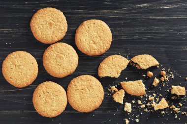 Eski siyah ahşap arka planda yulaf ezmeli kurabiyeler.
