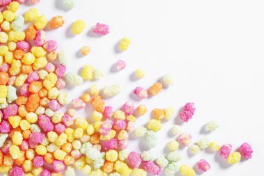 Gökkuşağı renkli kabarık mısır ve pirinç şekerleme beyaz arka planda, kopya alanı ile üst görünüm