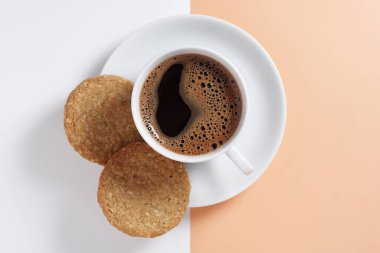 Yulaflı bisküvi ve renkli arka planda bir fincan kahve.