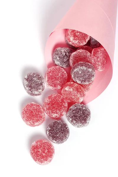 Fruit gum coated with sugar in a paper bag on white background