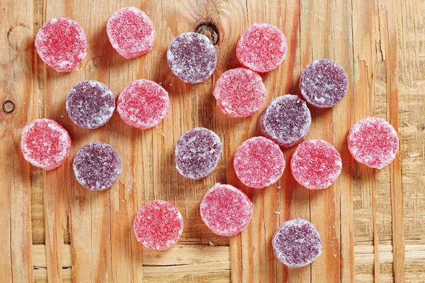 Fruit pastilles sweets on old wooden background, top view