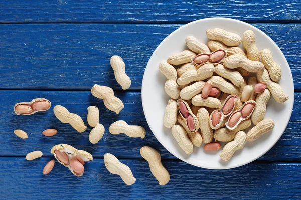 Erdnüsse Auf Einem Teller Auf Altem Blauen Holzgrund Draufsicht — Stockfoto
