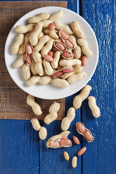 Erdnüsse Auf Einem Teller Auf Altem Blauen Holzgrund Draufsicht — Stockfoto