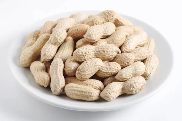 Ungeschälte Erdnüsse Auf Einem Teller Auf Weißem Hintergrund Nahaufnahme — Stockfoto