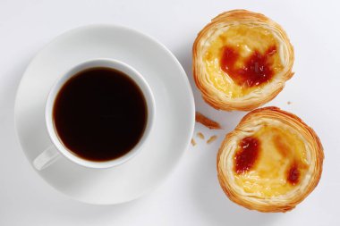 Portekiz yumurtalı tart pastel de nata ve beyaz arka planda bir fincan kahve.