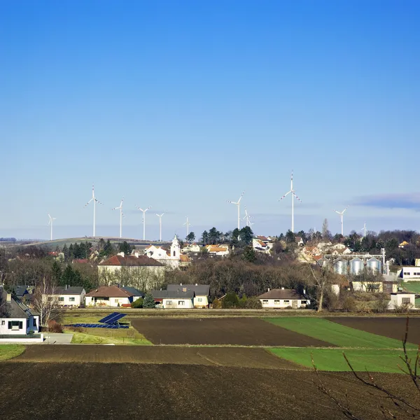 Centrale elettrica - parco eolico - oltre a piccola città sotto cielo azzurro — Foto Stock