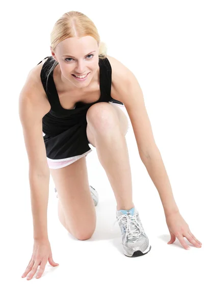 Junge Frau in Startposition für den Sprint Stockbild