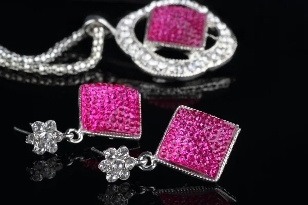 Roze gekleurde sieraden instellen met oorbellen in focus — Stockfoto