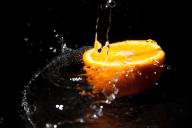 siyah zemin su sıçramalarına ile yarım portakal