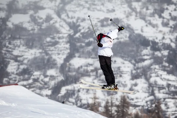 Un salto con gli sci, con gli sci incrociati contro una montagna — Foto Stock