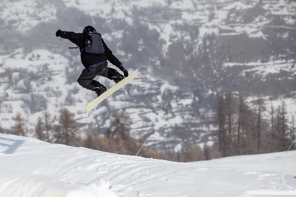 Ein Freeride-Skispringer mit gekreuzten Skiern gegen ein Gebirge — Stockfoto