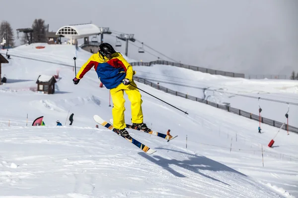 A free-ride ski jumper, with skis crossed against a mountains — Stock Photo, Image