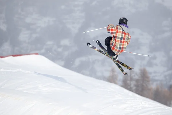 Ein Freeride-Skispringer mit gekreuzten Skiern gegen ein Gebirge — Stockfoto