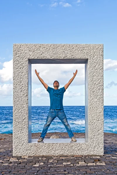 Giovane con le braccia spalancate dentro una scultura — Foto Stock