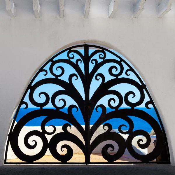 Вид через декоративные ворота на море — стоковое фото