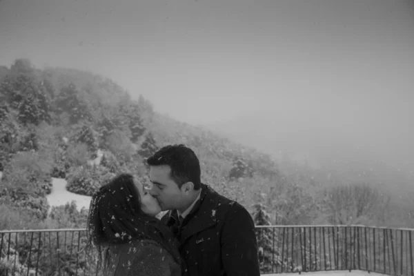 Pareja besándose bajo los copos de nieve —  Fotos de Stock