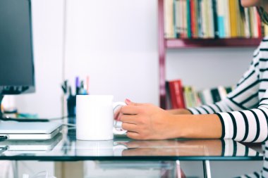 nő kezében egy fehér kupa