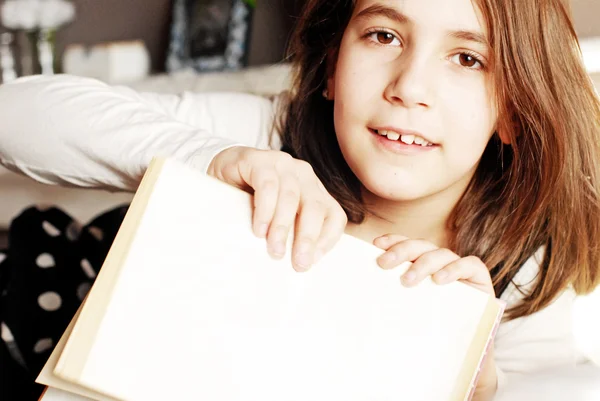 Niña señalando con el dedo en el libro en blanco con espacio de copia — Foto de Stock