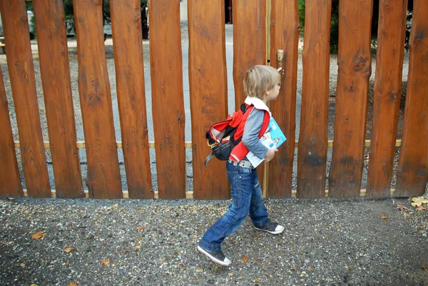 Jeune garçon debout sur une clôture en bois — Photo