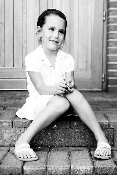 Little girl sitting on the stairs — Stock Photo, Image