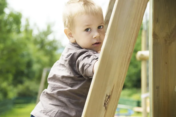 Liten pojke leker på lekplatsen — Stockfoto