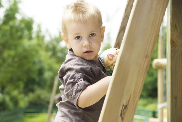 Liten pojke leker på lekplatsen — Stockfoto