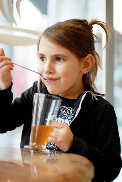 Niña bebiendo té en la cafetería — Foto de Stock