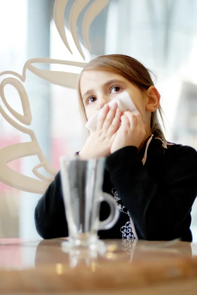 Kleines Mädchen trinkt Tee im Café — Stockfoto