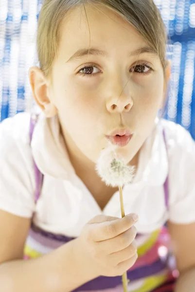 Beautiful little girl blowing dandelion — Stock Photo, Image
