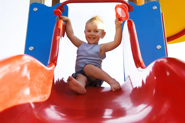 Kleine jongen op de dia. — Stockfoto