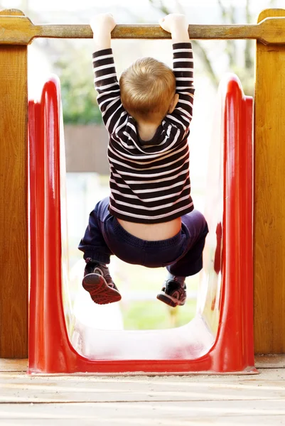 Kleine jongen spelen op de speelplaats — Stockfoto