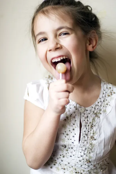 Cute little girl licking lollipop — Stock Photo, Image