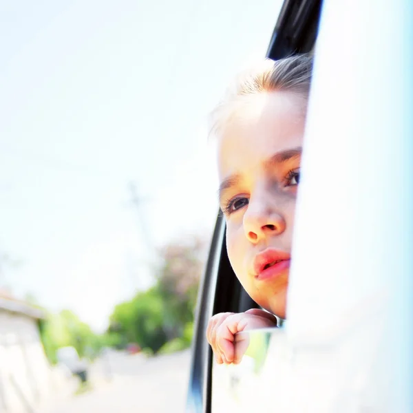 Meisje in de auto op zoek gooien venster — Stockfoto