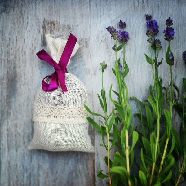 Lavender bag and some fresh lavender flowers on at wooden box — Stock Photo, Image