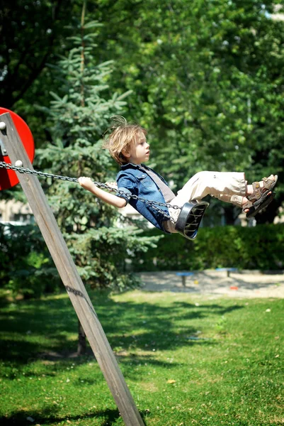 Kleine jongen spelen op de speelplaats — Stockfoto