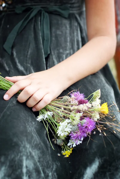 Детская рука с дикими цветами — стоковое фото