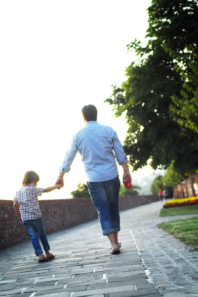 Hombre con hijo caminando y cogido de la mano — Foto de Stock