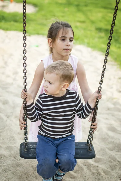 Zus en broer spelen op de speelplaats — Stockfoto