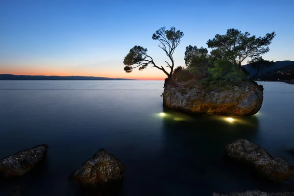 Solnedgang ved stranden med Kamen Brela (Brela Stone), Brela, Adriaterhavet, Kroatien - Stock-foto