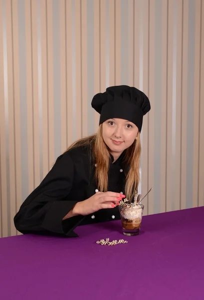 vrouwelijke chef-kok conditer in zwarte jas versieren tiramisu dessert