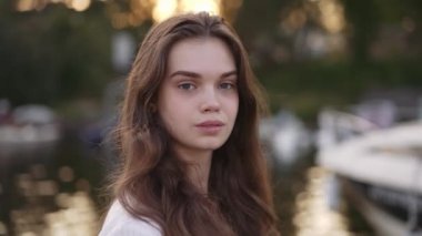 The girl looks into the camera and extends her hand to the camera.