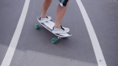 Kız sokakta kaykaya biniyor.