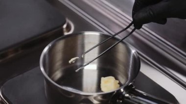 Restorandaki aşçı tereyağını kızgın tavaya koyar.