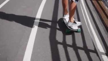 Kız sokakta kaykaya biniyor.