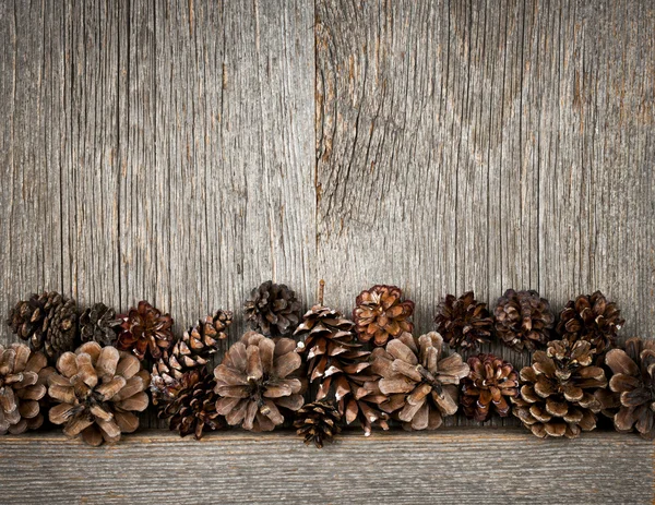 Fondo madera con conos de pino — Foto de Stock