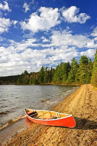 Canoa rossa sulla riva del lago — Foto Stock