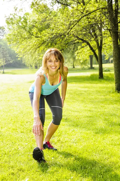 Woman stretching in park — Stock Photo, Image