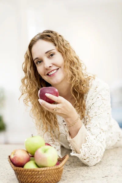 Donna sorridente con mela in mano — Foto Stock