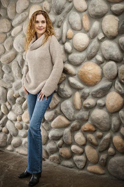 Mujer frente a la pared de piedra —  Fotos de Stock