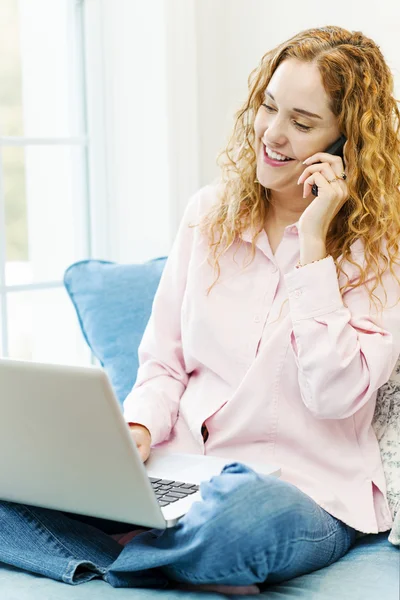 Kobieta rozmowa na telefon i za pomocą komputera — Zdjęcie stockowe